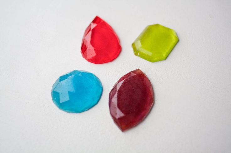 three different colored stones on a white surface