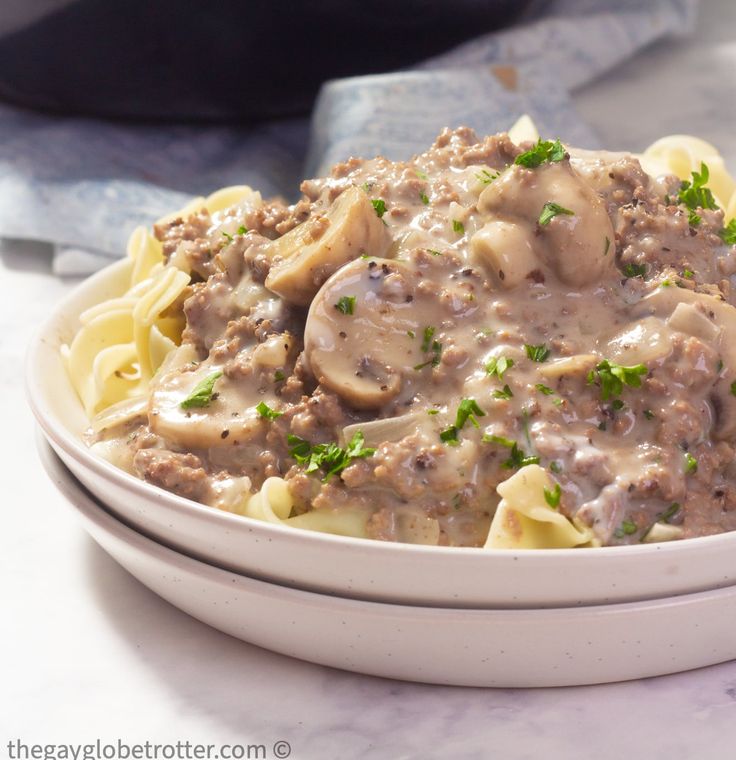 a white bowl filled with pasta covered in mushroom gravy