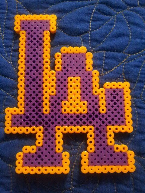 a close up of a purple and yellow beaded object on a blue quilted surface