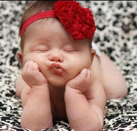 a baby with a red headband laying down