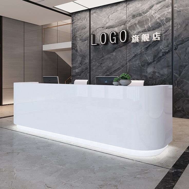 a white reception desk in front of a black and gray wall with the word logo on it