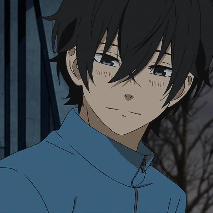 an anime character with black hair and blue shirt looking at the camera while standing in front of trees