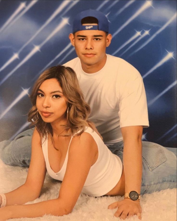 a man and woman posing for a photo in front of a blue background with stars