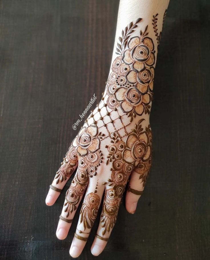 a woman's hand with henna tattoos on it