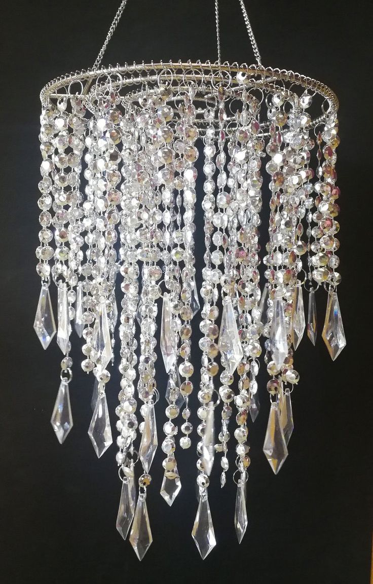 a chandelier hanging from the ceiling with lots of crystal beads and chains on it