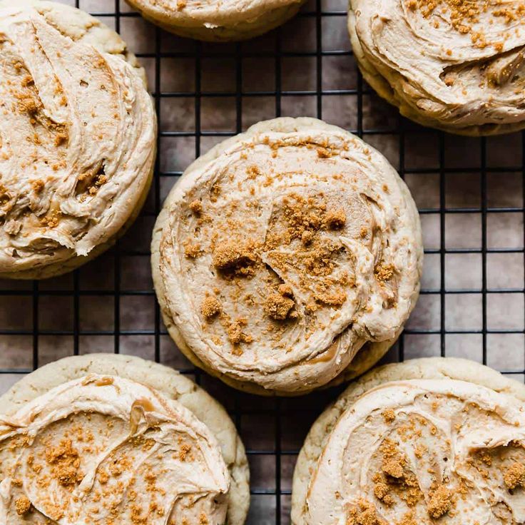 several cookies with frosting and cinnamon sprinkles on a cooling rack