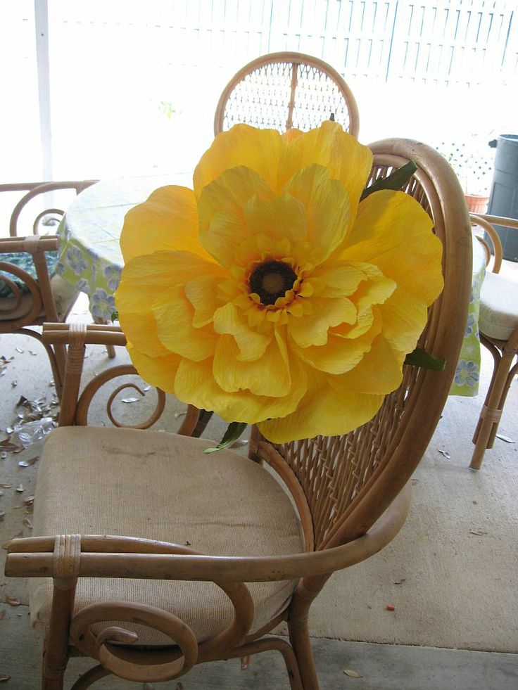 a large yellow flower sitting on top of a chair