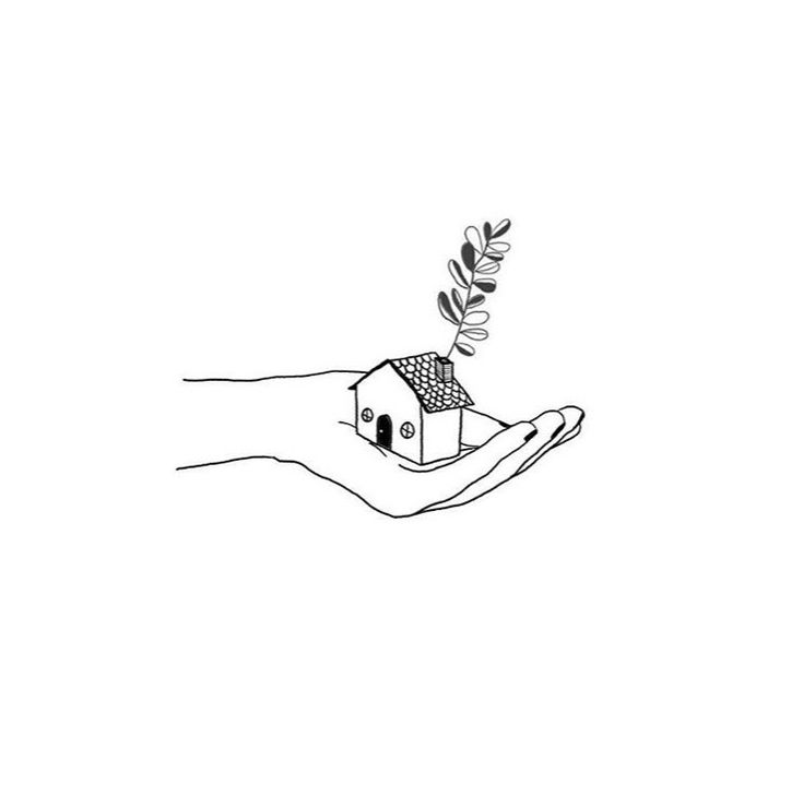 a hand holding a small house with a tree growing out of it