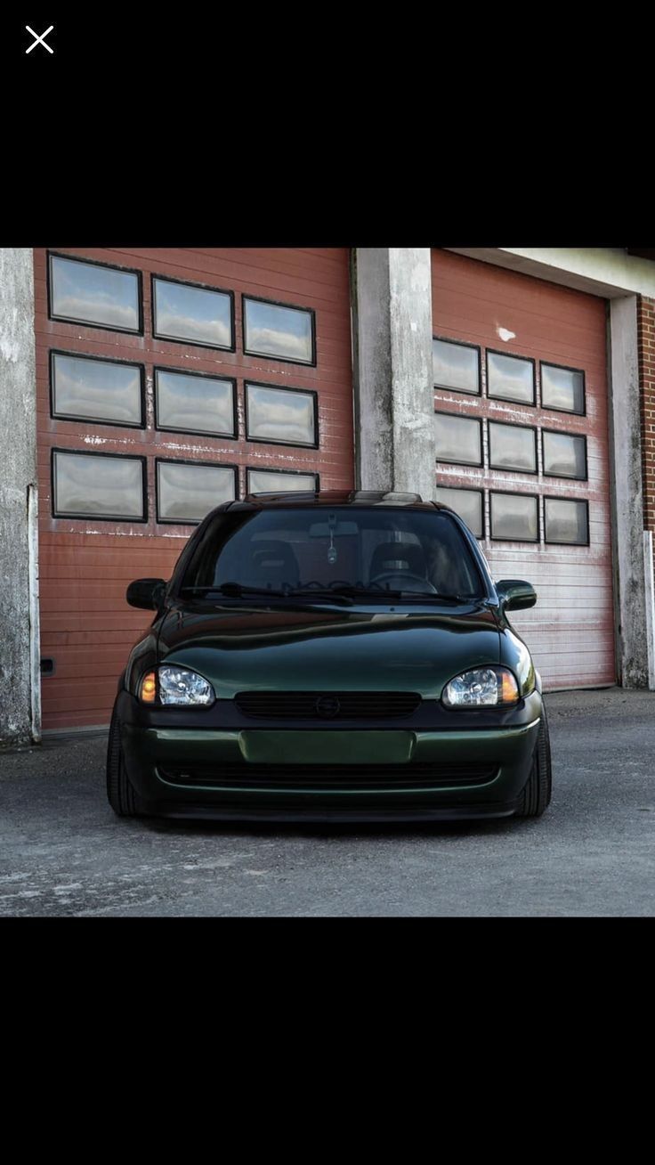 a black car parked in front of a garage