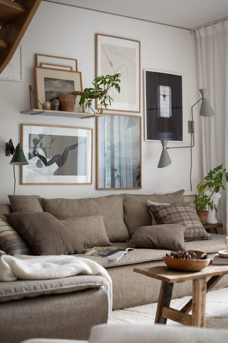 a living room filled with lots of furniture and pictures on the wall above it's coffee table