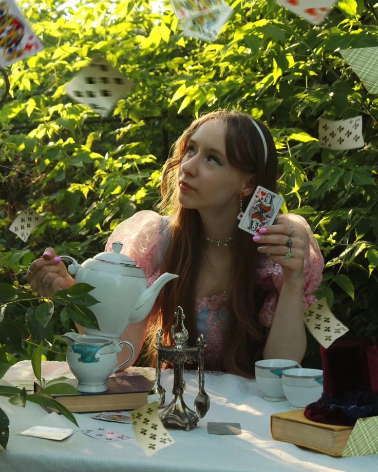 a woman sitting at a table with cards in front of her and looking up into the sky