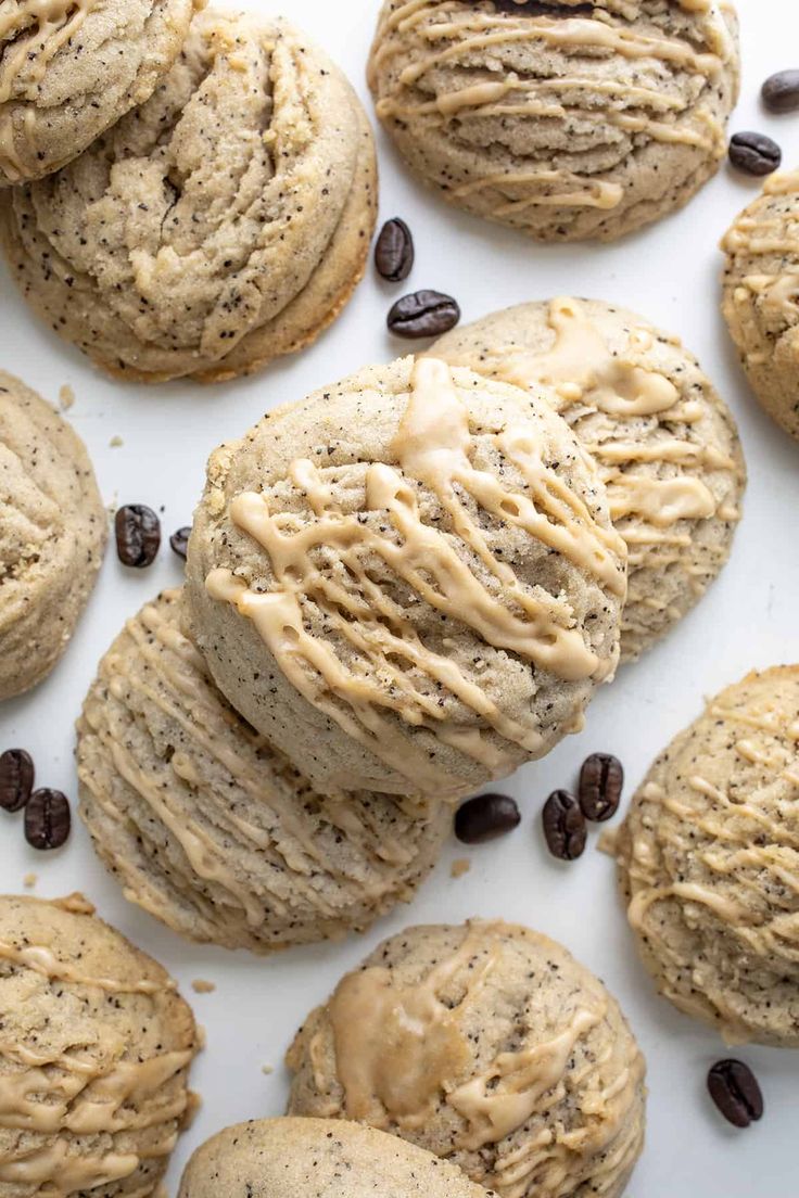 chocolate chip cookies and coffee beans are arranged on a white surface with frosting in the middle