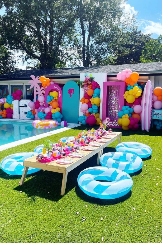 an inflatable pool is set up for a birthday party with balloons and decorations