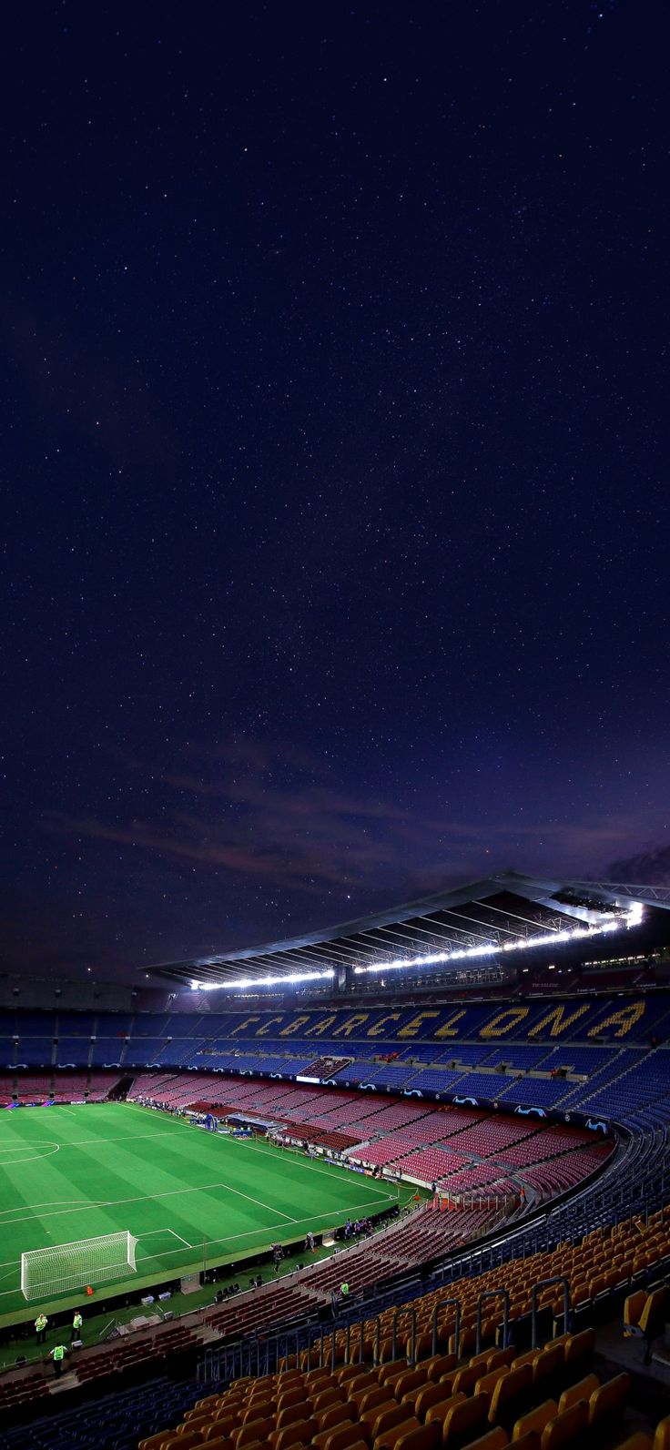 an empty soccer stadium at night with the lights on and stars in the sky above