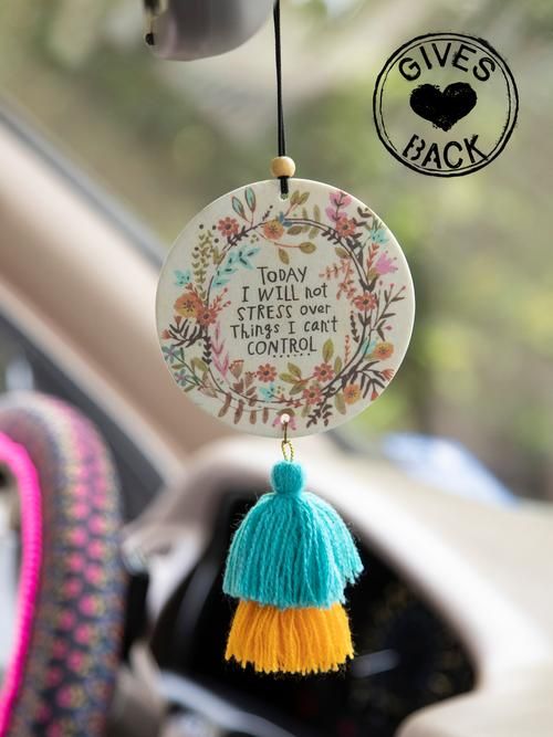 a car dashboard with a tassel hanging from it's center console and the words give back