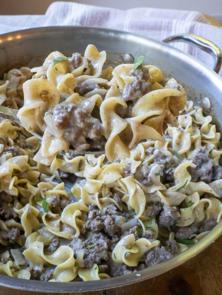 a skillet filled with pasta and meat