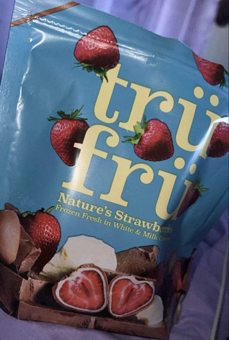 a bag of truffri with strawberries on it sitting on a bed