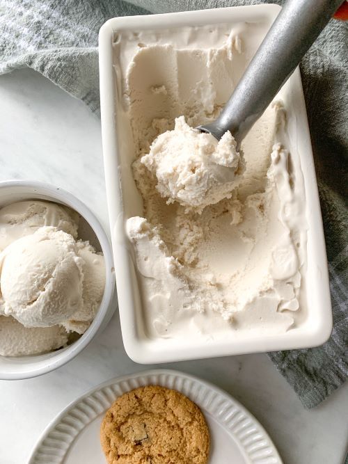 an ice cream and cookie are on the table next to each other with a scoop of ice cream