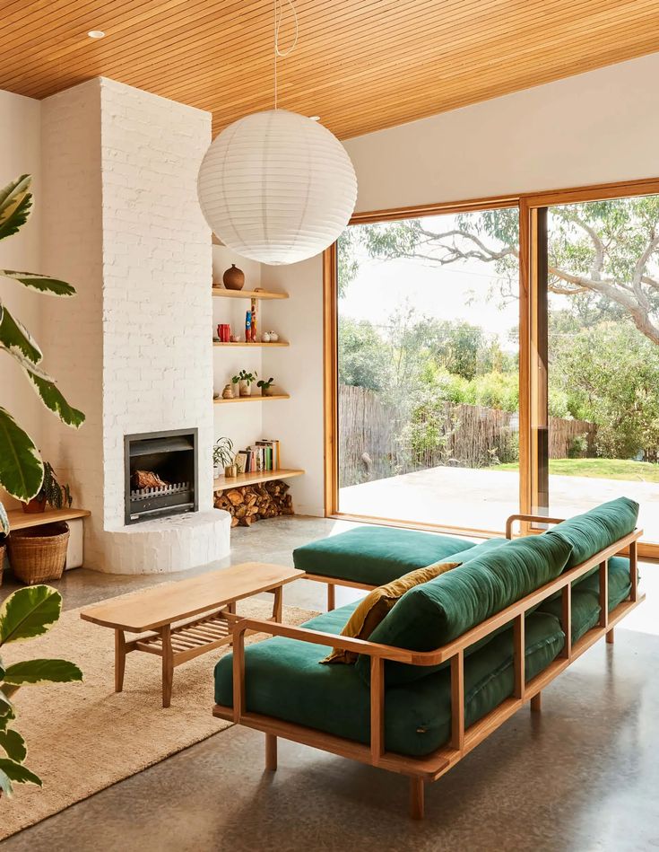 a living room filled with furniture and a fire place in front of a large window