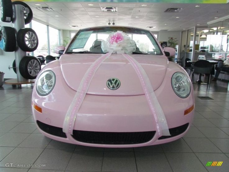 a pink car with a bow tied to it