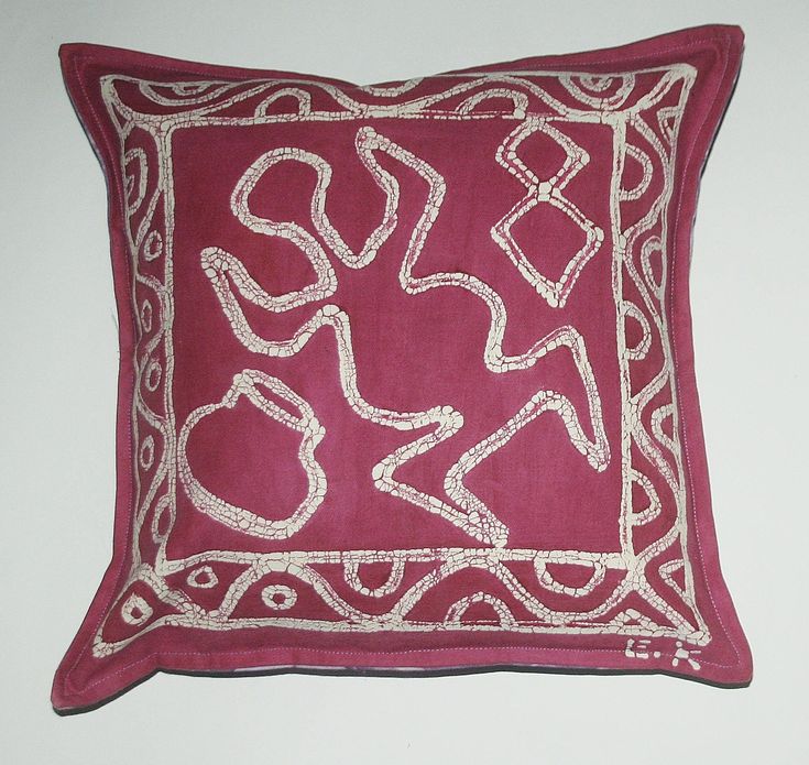 a red and white decorative pillow on a wall