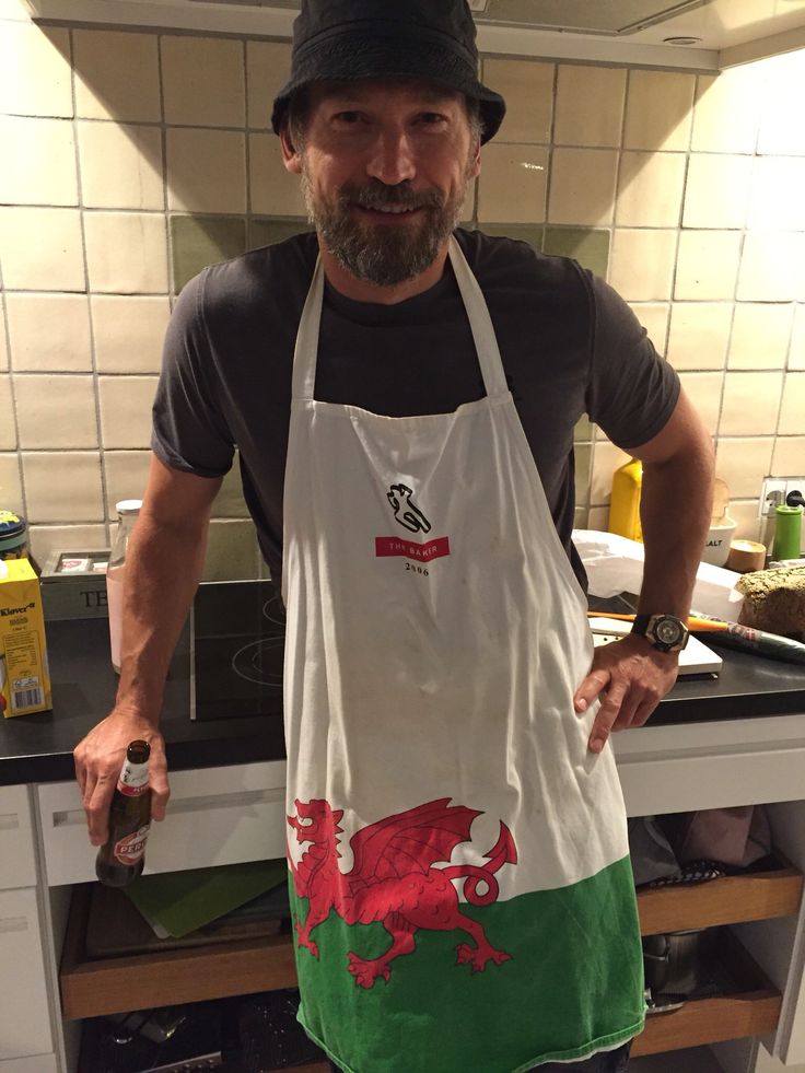 a man standing in a kitchen with an apron on