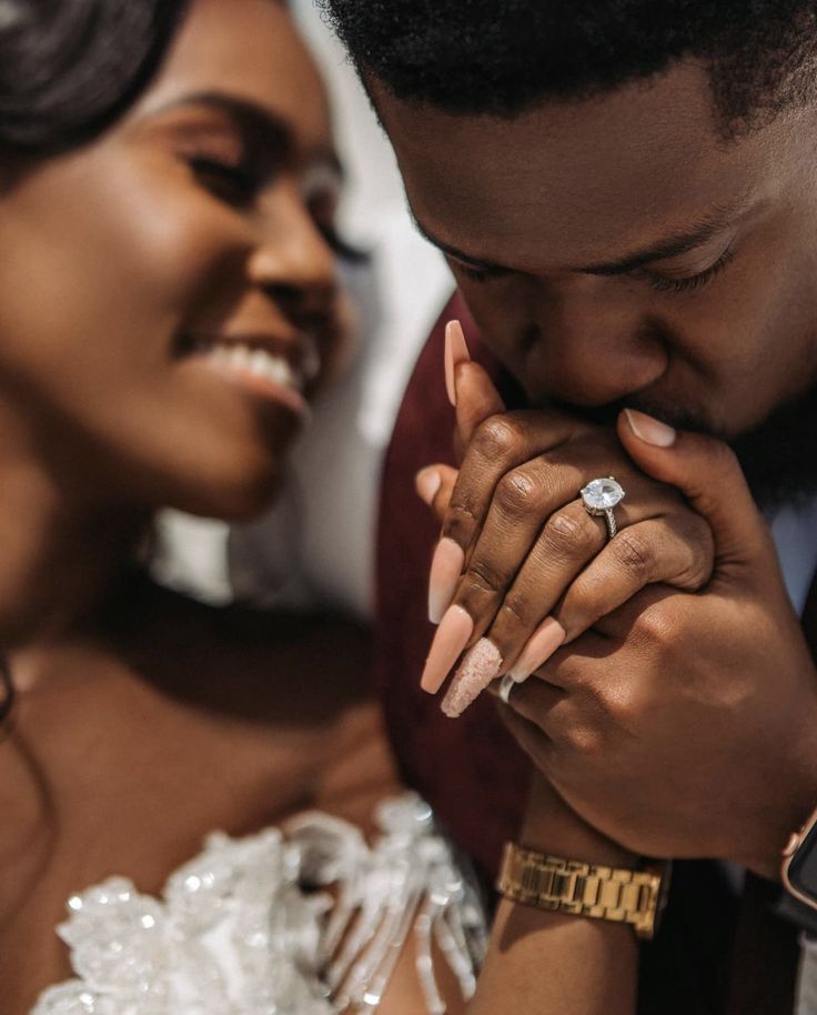 a man and woman holding each other's hands while they look at the camera