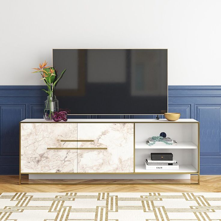 an entertainment center with a large television on it's stand in front of a blue wall