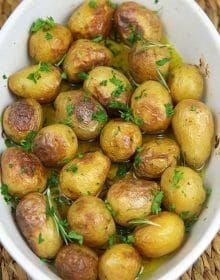 a white bowl filled with potatoes and herbs