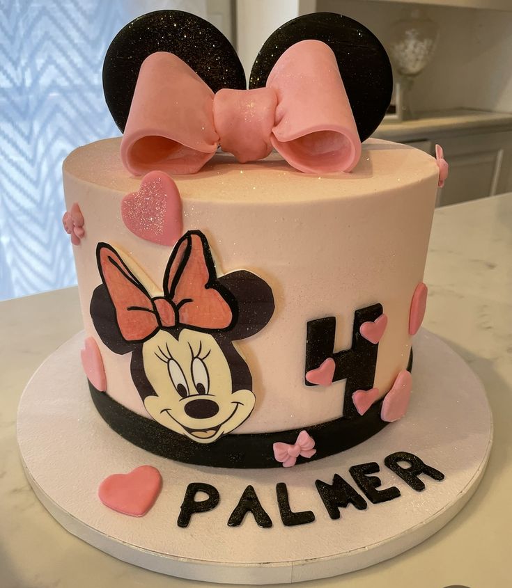 a minnie mouse cake with pink bows on top