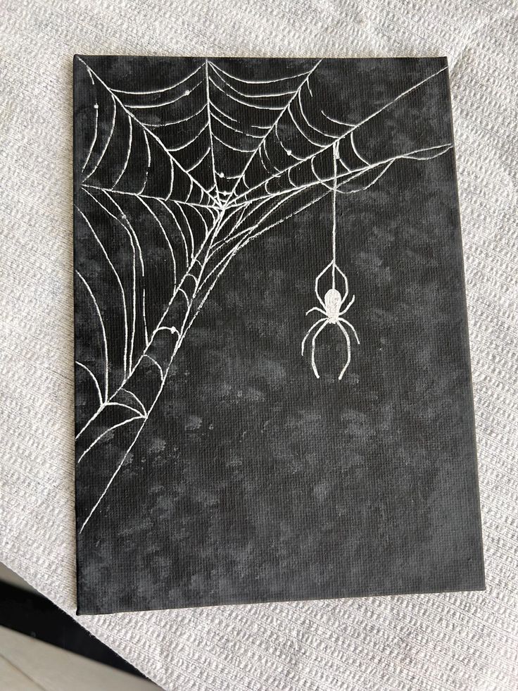 a spider web hanging from the side of a piece of paper