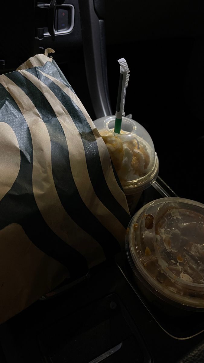 two plastic containers filled with food sitting on top of a car seat next to a bag