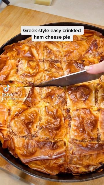 a person cutting into a pie on top of a wooden table