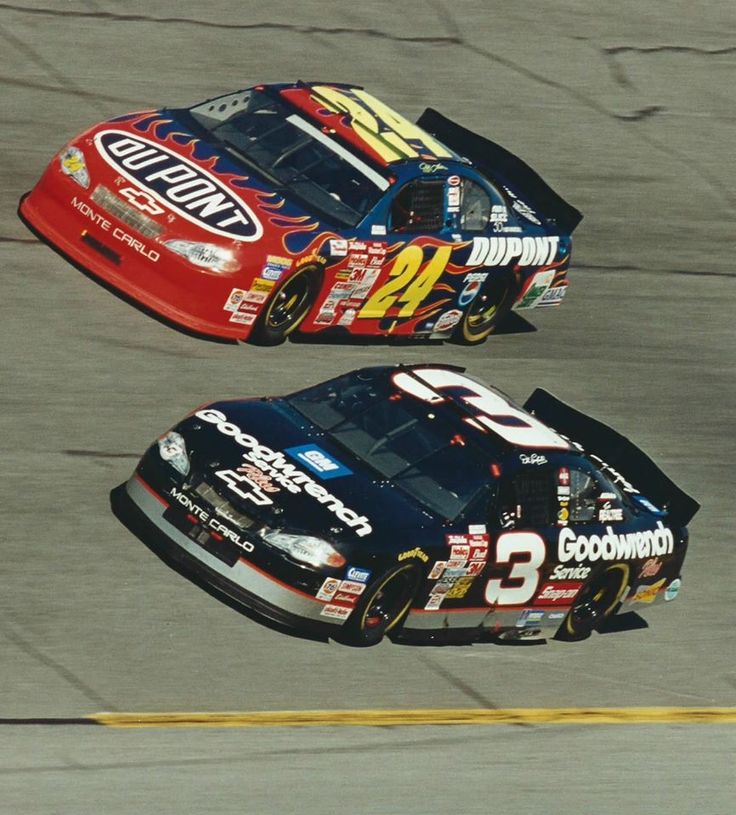 two racing cars driving on a track next to each other