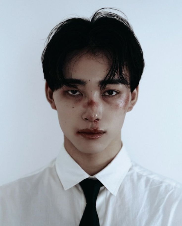 a young man wearing a white shirt and black tie with freckles on his face