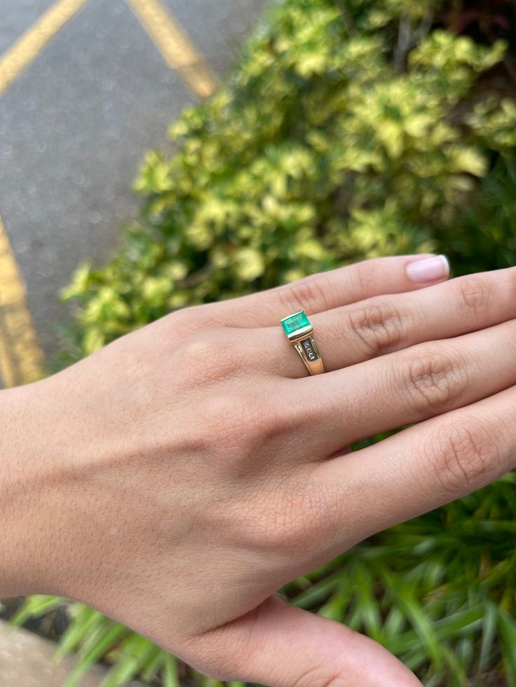 A unique Colombian emerald and diamond ladies' ring. A beautiful, medium-light green Colombian emerald weighing approximately 0.86-carats, with diamond accents on each side. The Colombian emerald is tension-set in a 14K yellow and white gold setting. Perfect for everyday use. Setting Style: Tension Setting Material: 14K Yellow & White Gold Gold Weight: 4.3 Grams Main Stone: Emerald Shape: Emerald Cut Weight: 0.86-Carats Clarity: Transparent Color: Medium Green Luster: Excellent - Very Good O Elegant 14k Stamped Emerald Ring, 14k Gold Green Diamond Princess Cut Ring, Princess Cut Green Diamond Ring In 14k Gold, Green Princess Cut Diamond Ring In 14k Gold, Luxury Green Birthstone Ring For May, Luxury Green May Birthstone Ring, Green Diamond Ring With Vvs Clarity, Fine Green Diamond Ring With Vvs Clarity, Green Princess Cut Diamond Ring In Fine Jewelry Style