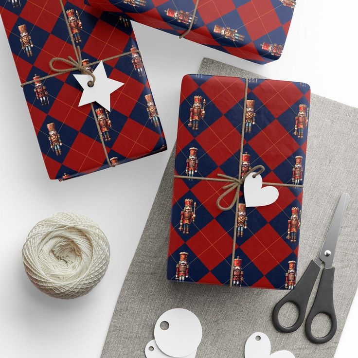 wrapping presents with red, blue and white designs on them next to twine of scissors