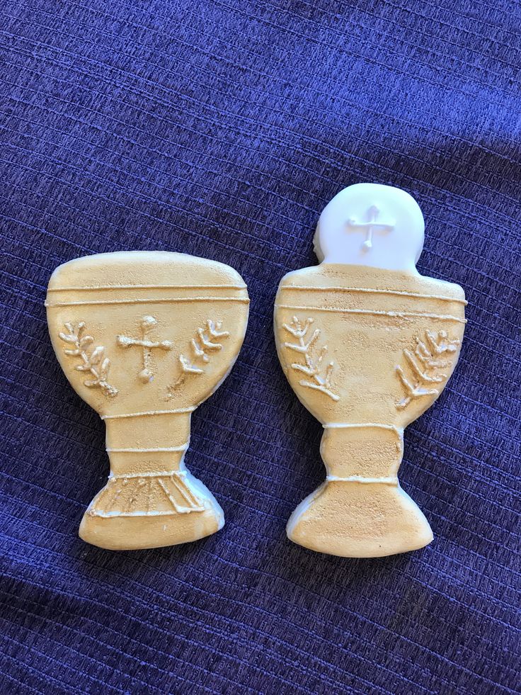 two ceramic vases sitting on top of a blue cloth