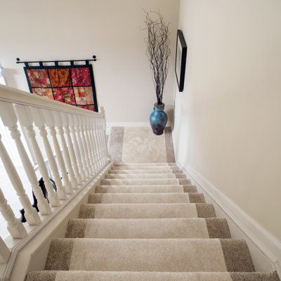 a staircase with carpeted steps leading up to a painting on the wall