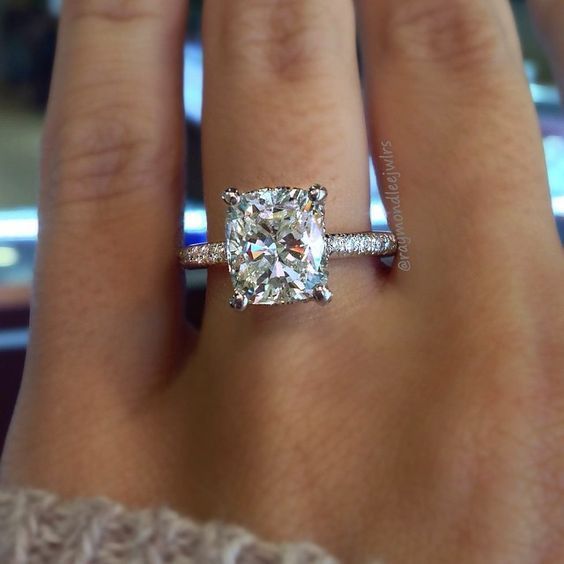 a woman's hand with a ring on it and a diamond in the middle