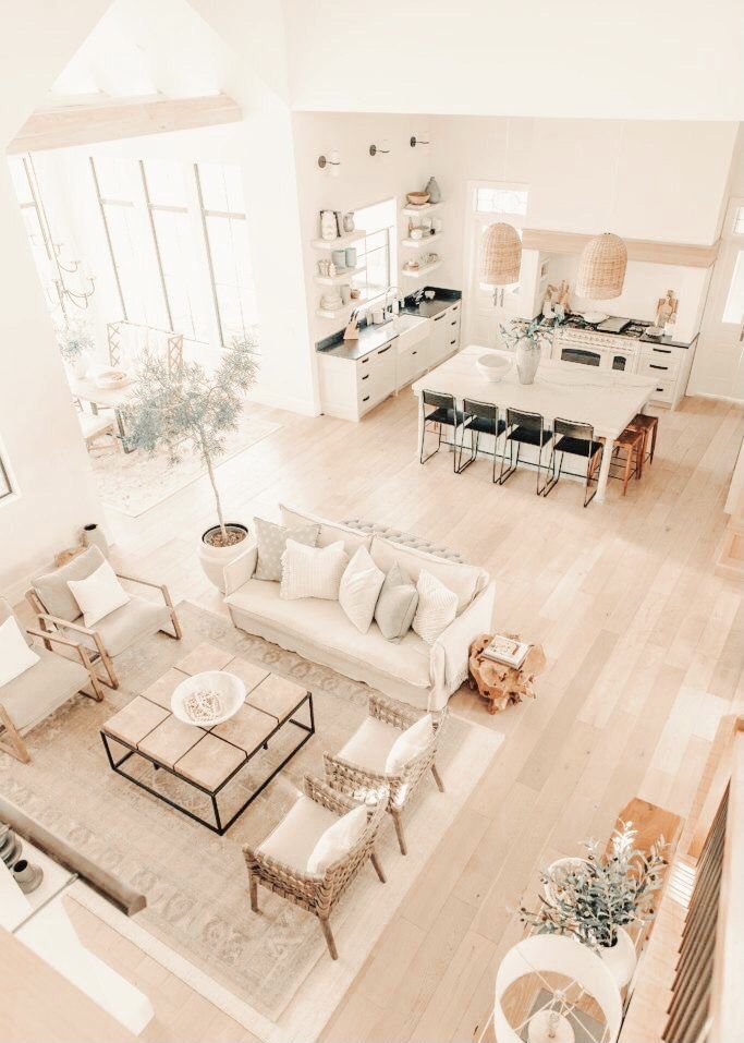 an aerial view of a living room with white furniture and wood floors, along with large windows