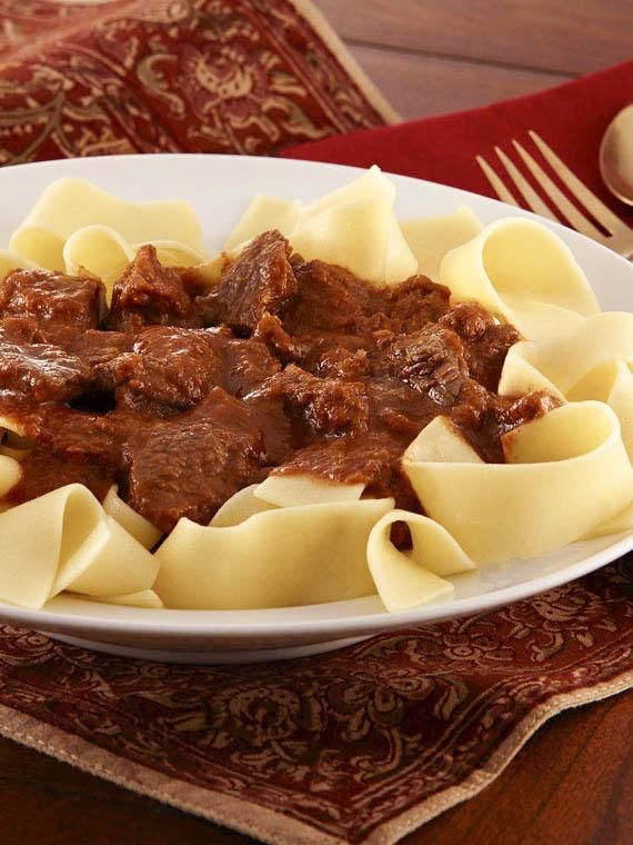 a white plate topped with pasta and beef