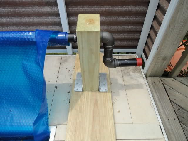 a piece of wood sitting on top of a wooden floor next to a blue pipe