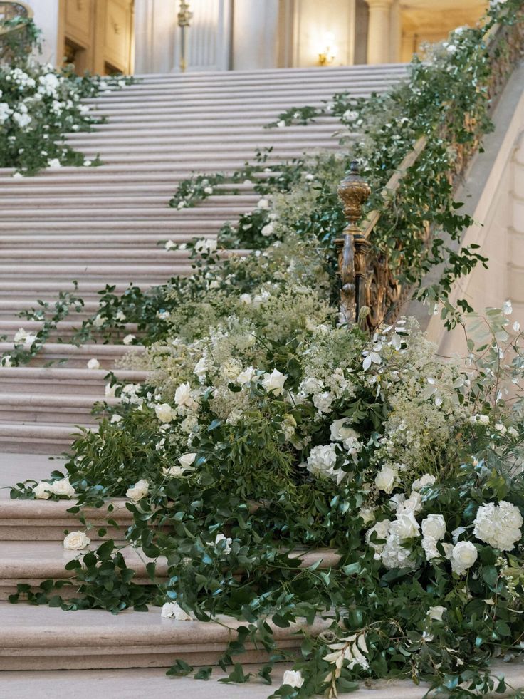 white flowers and greenery are growing on the steps