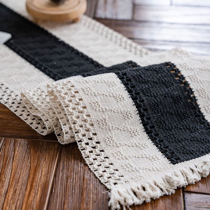 a black and white rug on top of a wooden floor next to a piece of wood