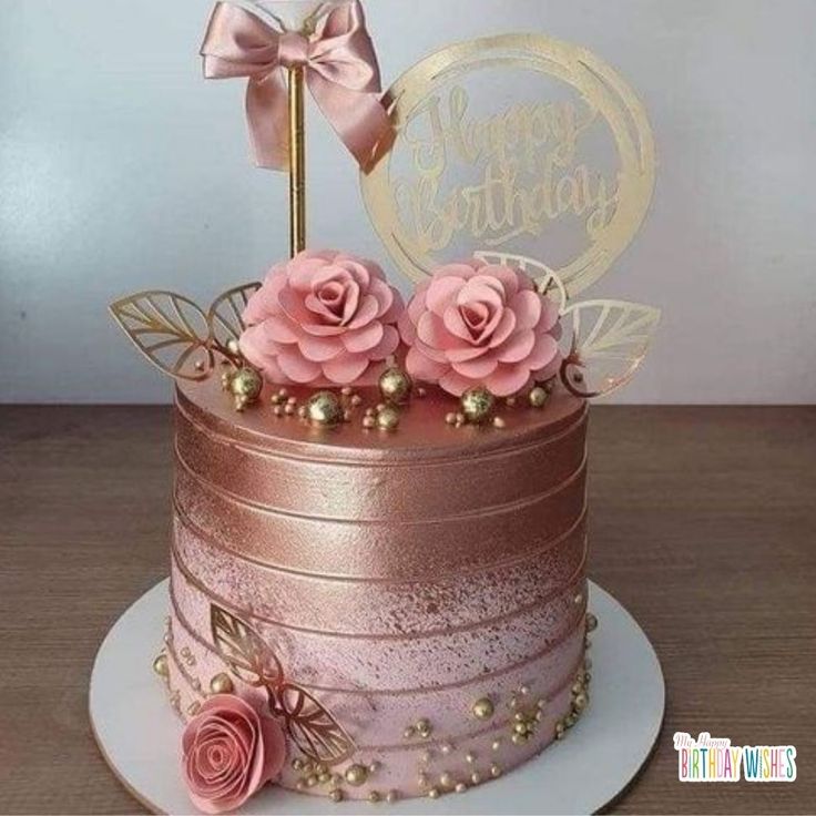 a pink and gold birthday cake with roses on top