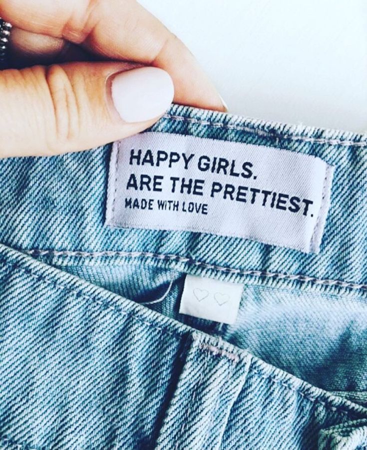 a woman's hand holding up a label that says, happy girls are the prettiest made with love