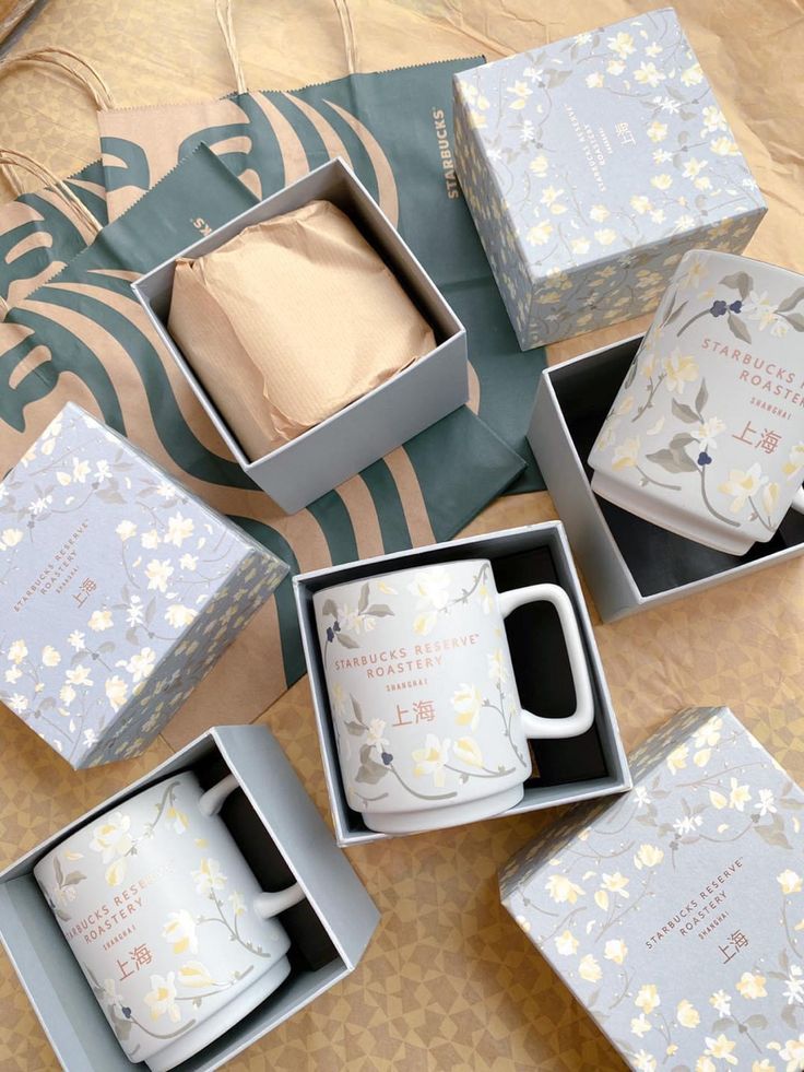 six boxed coffee mugs sitting on top of a bed next to each other in boxes