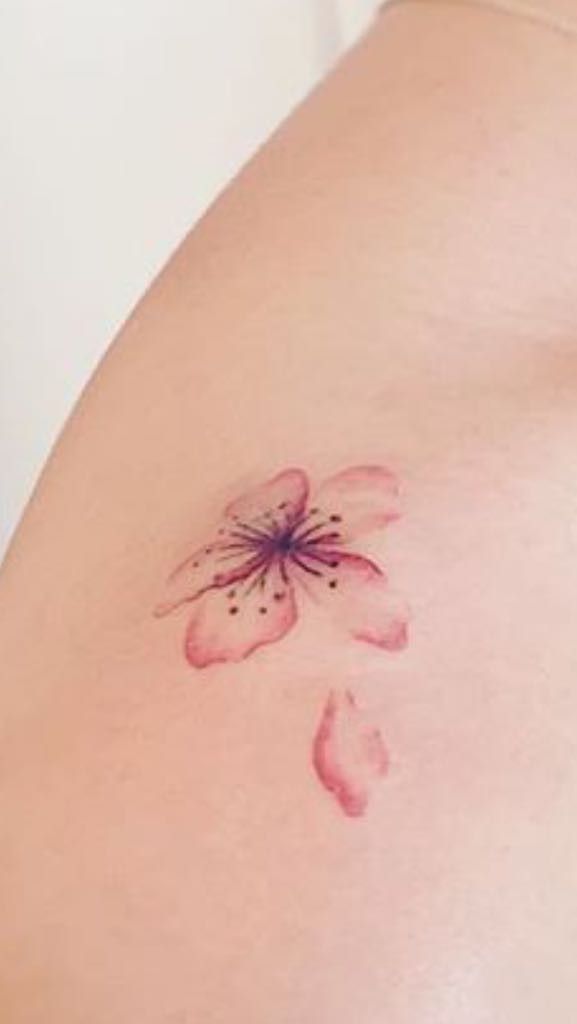 a woman's stomach with a flower tattoo on it