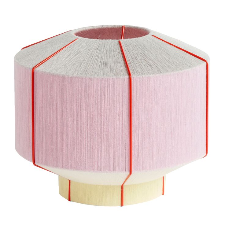 a pink and white lamp shade sitting on top of a table